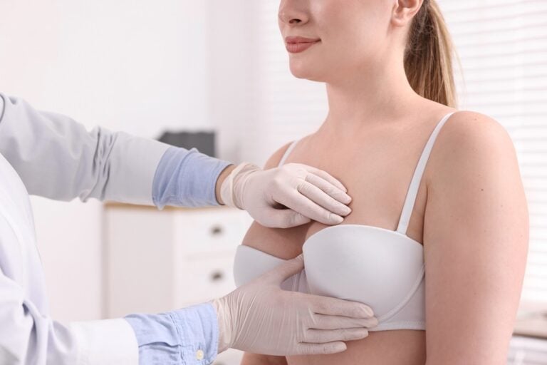 expert checking woman's breast in clinic