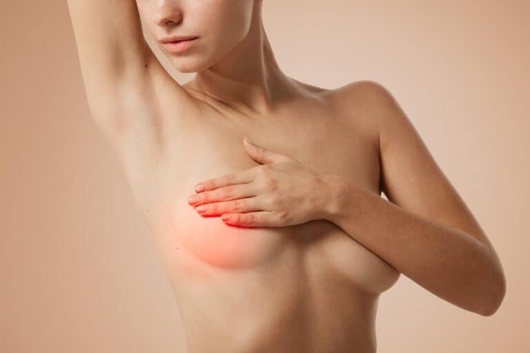 woman's upper body with hands covering breasts