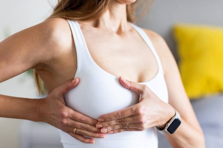 woman performing breast exam