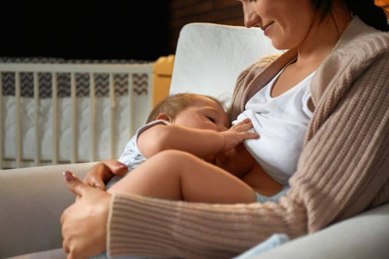 woman smiling breastfeeding her baby